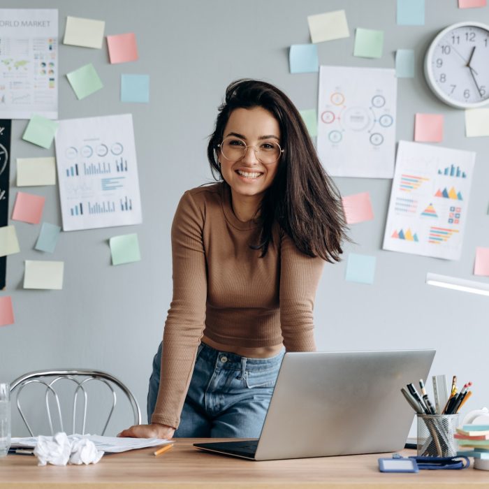 cute-smiling-business-girl-with-glasses-in-the-office-leaning-on-the-desk-.jpg
