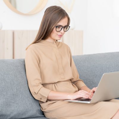 young-business-woman-sitting-on-sofa-with-open-laptop-working-from-home.jpg